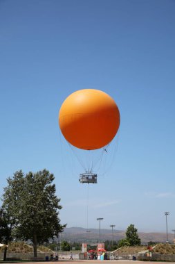 Irvine, California - USA - June 2, 2022: The Orange Balloon in the Great Park in Irvine, California. A beautiful free ride in the Orange Balloon reaching up 400 feet into the sky.   