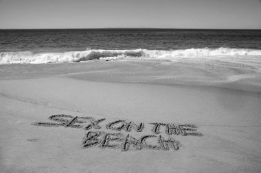 sex on the beach written in the sand on the beach.  message handwritten on a smooth sand beach 