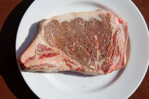 ステーキだ ビーフ ステーク 新鮮な生牛ステーキ 白い皿の上のステーキ セラミックプレート上の生肉 Tボーンステーキ 牛肉のカット 焼き肉 ポーターハウスだ — ストック写真