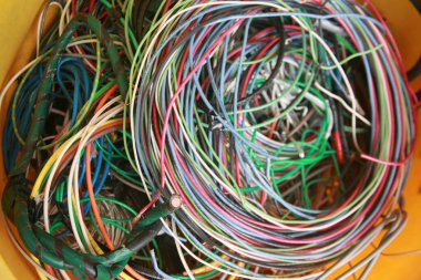 Lake Forest, California - ABD - 7 Mayıs 2023: bakır tel. Geri dönüşüm için elektrik kablosunu parçalayın. Eski elektrik teli. Renkli kabloların dağınık yığını. Çok renkli kabloların ağ karmaşası. Yapı atıkları