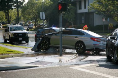 Lake Forest, California - USA - April 26, 2023: Major Car Accident. Car running over a Fire Hydrant and causing Flooding and a Water Hazard from a collision. Car Accident destroys a Fire Hydrant. clipart