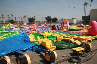 Buena Park, California - ABD - 27-2023 Nisan - Otoparkta şişme oyuncaklar. Çocuklar için şişirilebilir şişirilebilir oyuncaklar. Renkli şişme çocuklar şatolarda, slaytlarda ve zıplayan evlerde parti veriyor..