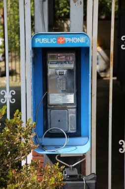 Plasentia, California - ABD - 8 Mart 2023: Bozuk ve engelli ankesörlü telefon. Ankesörlü telefonlar eskiden popülerdi ve her yerde kullanılırdı. Cep telefonları artık herkes tarafından kullanılıyor..