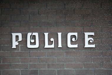 POLİS. Duvarda polis işareti var. Polis departmanı. Polis, insanları Suç ve Terörden korumak için önemli bir iş yaptı.
