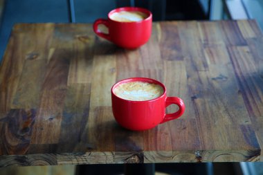 Latte. coffee cup latte art. Cappuccino or latte with frothy foam, Red coffee cup. Top view closeup. In a Coffee Shop. Cafe and bar, barista art concept. Latte Art in a Cup of Hot Coffee.