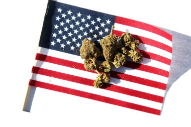 Cannabis. Legal Marijuana. Marijuana Buds with an American Flag. Female Marijuana Flowers. American Medical Marijuana. Recreational Cannabis. Cannabis flowers with the American Flag.