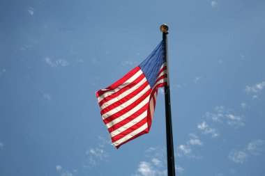 Amerikan Bayrağı. Anma Günü 'nde Amerikan Bayrağı Esintisi. 4 Temmuz tatili için Amerikan Bayrağı. Mavi Gökyüzü arka planında dalgalanan Amerikan bayrağı. ABD. Yıldızlar ve Çizgiler.