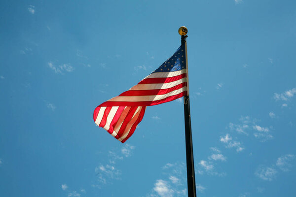 American Flag. American Flag Waving in the breeze for Memorial Day. US Flag for the 4th of July holiday. American flag fluttering in the breeze with a Blue Sky background. USA. Stars and Stripes.