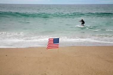 Amerikan Bayrağı. Sahilde esen meltemde bir Amerikan Bayrak İğnesi. Kumsalda Amerikan bayrağı. 