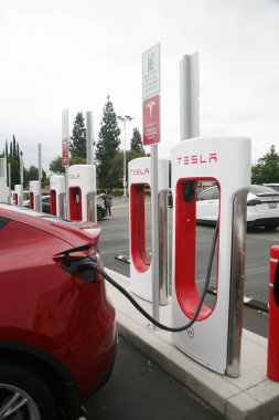 Irvine, California - ABD - 21 Haziran 2023: Tesla Elektrikli Otomobil Şarj İstasyonu. Tesla Superşarj istasyonunda birçok araba şarj oluyor. Süperşarj istasyonları Tesla arabalarına hızlı şarj olanağı sağlıyor.