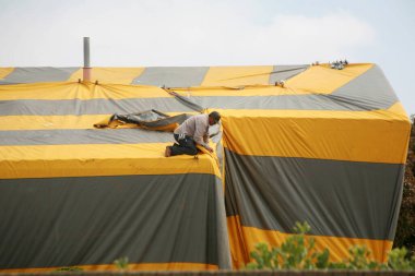 Irvine, California - ABD - 17 Mayıs 2023: Sarı ve gri termit çadırıyla kaplı çiftlik evi. Termitler tarafından dezenfekte edilirken sarı ve gri bir çadır ile kaplı bir ev..