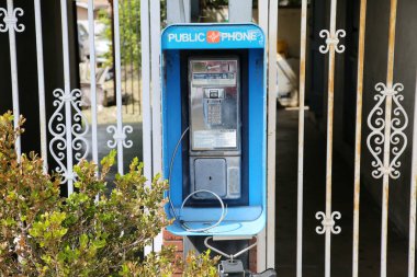 Plasentia, California - ABD - 8 Mart 2023: Bozuk ve engelli ankesörlü telefon. Ankesörlü telefonlar eskiden popülerdi ve her yerde kullanılırdı. Cep telefonları artık herkes tarafından kullanılıyor..