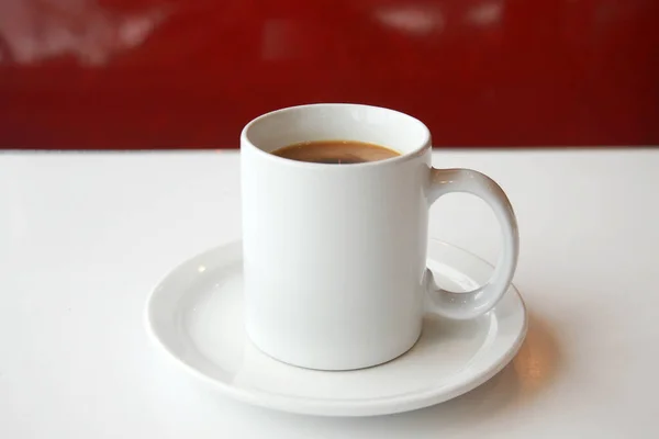 stock image Coffee. Cup of Coffee. Coffee cup on an old kitchen table. White mug of black coffee with cream. Morning Pick me up. Cup of Joe. Caffeine. Java with Cream and Sugar. Espresso in a ceramic mug.