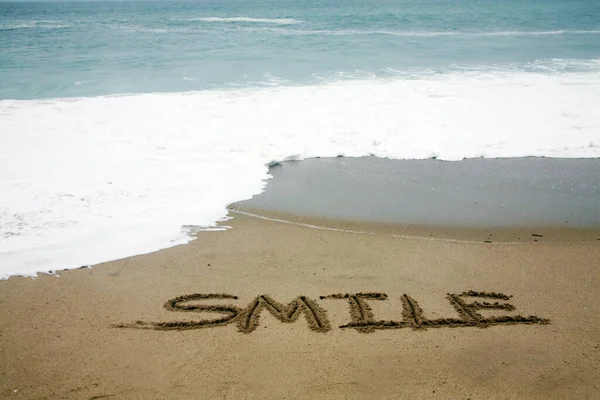 Uśmiech Napisany Piasku Plaży Oceanem Jako Tłem — Zdjęcie stockowe