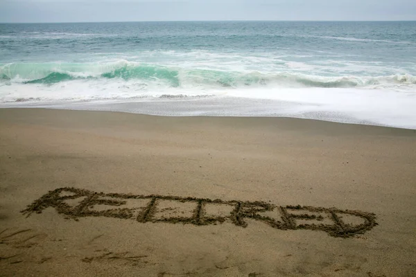 Συνταξιούχος Γραμμένο Στην Άμμο Παραλία Φόντο Τον Ωκεανό — Φωτογραφία Αρχείου