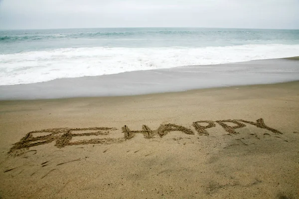 Счастливым Написанное Пляжном Песке Океаном Качестве Фона — стоковое фото
