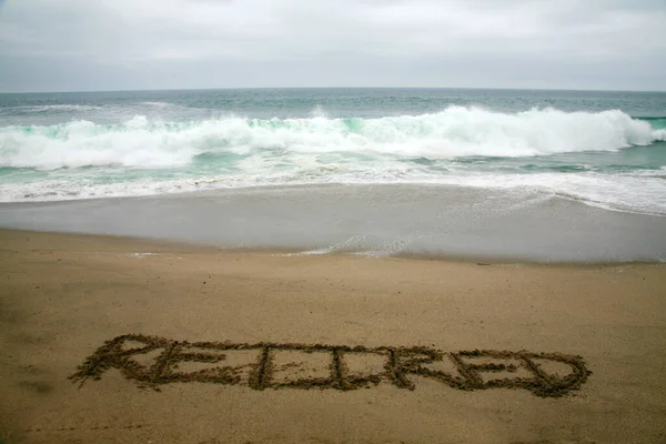 Συνταξιούχος Γραμμένο Στην Άμμο Παραλία Φόντο Τον Ωκεανό — Φωτογραφία Αρχείου