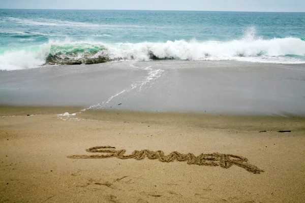 海を背景にした砂浜に書かれた夏 — ストック写真