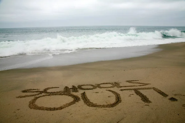 海を背景にビーチサンドで書かれた学校 — ストック写真