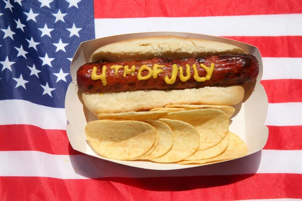ホットドッグだ 愛国的なホットドッグのマスタード 7月4日 ホットドッグ 7月4日黄マスタードでホットドッグに書かれた アメリカ愛国的なピクニック休暇 ホットドッグ — ストック写真
