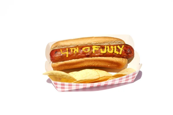 用黄色芥末写的7月4日文的热狗 午餐的热狗 与白种人隔离 — 图库照片