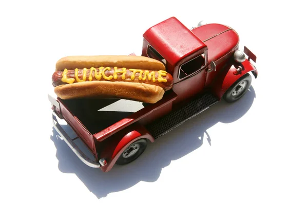 黄マスタードで書かれた単語のランチタイムとホットドッグ お昼はホットドッグ 白に隔離されてる 文中の赤いトラックの中のホットドッグ — ストック写真