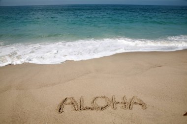 The word ALOHA written in the sand on the beach in Hawaii. clipart