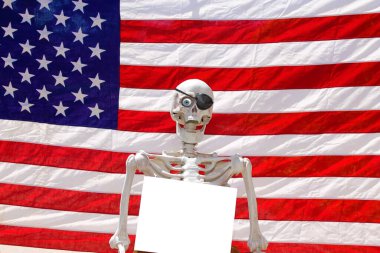 İnsan iskeleti bir fotoğraf kabininde boş bir kağıt poster tutuyor.