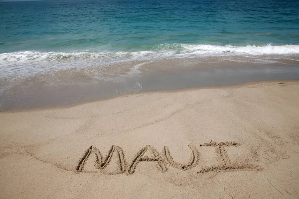 在太平洋背景的海滩上 毛伊在沙滩上写下的名字 — 图库照片