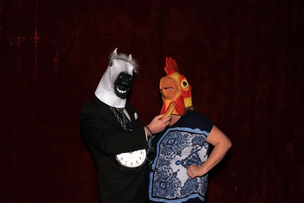 Two people wear Animal Head Masks and pose for pictures while in a Photo Booth