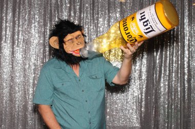 Lake Forest, California - ABD - 15 Mayıs 2016. Bir adam gülümseyerek fotoğraf kabininde çekilmek için poz verirken şişme Corona bira şişesi tutuyor. Fotoğraf kabinleri herkes için eğlencelidir..