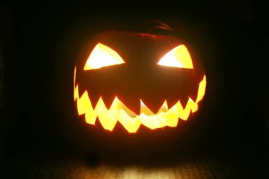 Jack O' lantern. Cadılar Bayramı Balkabağı. Siyahta parlayan Cadılar Bayramı Balkabağı. Cadılar Bayramı Jack O Lantern. Cadılar Bayramı eğlencesi. Hayalet yüzler. Korkunç balkabağı. Şeytanlar gülümser. Ürkütücü Jack. Balkabağı oyma eğlencesi.