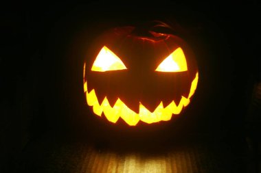 Jack O' lantern. Cadılar Bayramı Balkabağı. Siyahta parlayan Cadılar Bayramı Balkabağı. Cadılar Bayramı Jack O Lantern. Cadılar Bayramı eğlencesi. Hayalet yüzler. Korkunç balkabağı. Şeytanlar gülümser. Ürkütücü Jack. Balkabağı oyma eğlencesi.