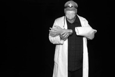 Bir doktor, elinin siyah arkaplanla kolundan ayrıldığını fark edince şok olur. Kötü İlaca dikkat et. Cadılar Bayramı kostümü. Acil tıbbi durum  