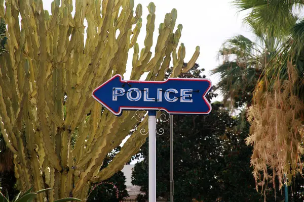 Police. Neon POLICE Arrow Sign. Police Sign pointing to the Police Station. Sign with cloudy sky. Neon Sign. Blue Neon. Red Neon. Advertising. Directions. Peace Officer. Cops are very important. Cops.