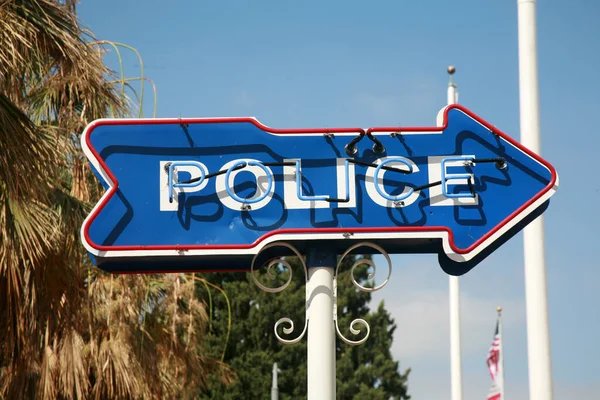 Police. Neon POLICE Arrow Sign. Police Sign pointing to the Police Station. Sign with cloudy sky. Neon Sign. Blue Neon. Red Neon. Advertising. Directions. Peace Officer. Cops are very important. Cops.