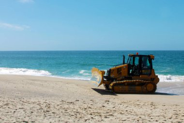 Kaliforniya, Laguna Sahili 'ndeki kumu bir buldozer temizliyor. Buldozerler kum patlamalarını taşımak ve insanların yaralanabileceği yerleri doldurmak için kullanılır.. 