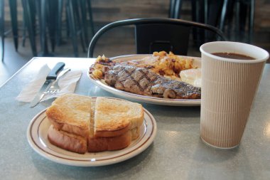 Biftek ve yumurta kahvaltısı. Biftekli kahvaltı, 3 yumurta, haşhaşlı patates, tereyağlı ekşi ekmek ve kremalı kahve. Yiyecek ve içecek. Yiyecekler. Kahvaltıda. Yumurtalar. Biftek. - Kahve. - Şerefe. Esrar Browns. Bıçak. Çatal. Kaşık. Tabak. - Öğle yemeği. Akşam yemeği. Atıştırmalık. 