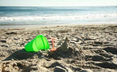 Yaz tatili, sıcak bir yaz gününde deniz ve sahil manzarası, kumsalda çocuk kumları oyuncakları, kumu kazmak. Kumdan kaleler ve kaleler yapmak. Okyanusta yüzüyordum. Güneş banyosu. Güneş yanığı. Güneş yanıkları. Tatil yeri. Egzotik Adalar. 