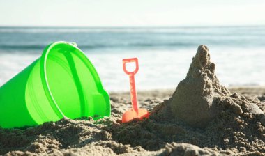 Yaz tatili, sıcak bir yaz gününde deniz ve sahil manzarası, kumsalda çocuk kumları oyuncakları, kumu kazmak. Kumdan kaleler ve kaleler yapmak. Okyanusta yüzüyordum. Güneş banyosu. Güneş yanığı. Güneş yanıkları. Tatil yeri. Egzotik Adalar. 