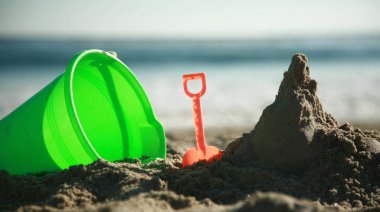 Yaz tatili, sıcak bir yaz gününde deniz ve sahil manzarası, kumsalda çocuk kumları oyuncakları, kumu kazmak. Kumdan kaleler ve kaleler yapmak. Okyanusta yüzüyordum. Güneş banyosu. Güneş yanığı. Güneş yanıkları. Tatil yeri. Egzotik Adalar. 