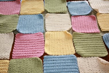 İplik. El yapımı renkli örülü battaniye. El yapımı örgü kareler ve bebek battaniyesine dikilmeye hazır iplikler. Örgü ya da örgü kareler. Örgü örmek için çeşitli ve parlak renkli iplikler. Yaratıcılık ve iğne işi için mallar. Örgü örüyorum. Düğüm