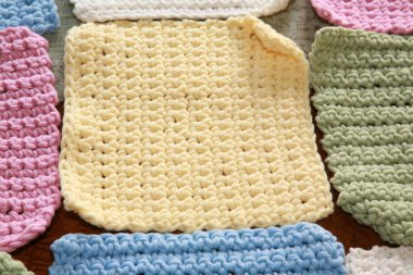 İplik. El yapımı renkli örülü battaniye. El yapımı örgü kareler ve bebek battaniyesine dikilmeye hazır iplikler. Örgü ya da örgü kareler. Örgü örmek için çeşitli ve parlak renkli iplikler. Yaratıcılık ve iğne işi için mallar. Örgü örüyorum. Düğüm