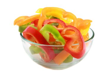 Çan biberi. Cam bir kasede leziz taze kesilmiş Bell Pepper dilimleri. Dilimler Yeşil, Sarı, Turuncu ve Kırmızı Çan Biberi. Beyazda izole edilmiş. Cam kasede dilimlenmiş renkli biberler. Renkli dolmalık biber dilimleri. Renkli tatlı biberler yemeye hazır. 