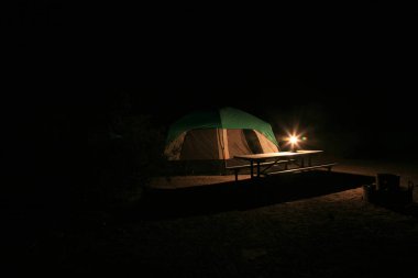 Kamp yapmak. Kamp alanında kurulmuş bir çadır. İnsanlar doğa ile iletişim kurmayı ve kamp yaparken dışarıda uyumayı severler. Dünyanın harikalarını ziyaret ediyorum. Ölüm Vadisi, Kaliforniya 'da kamp yapmak. Ölüm Vadisi çölün çok sıcak ve eski bir bölgesidir. Sıcak Saat