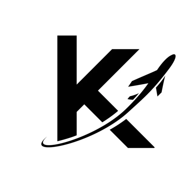 Black Lowercase Letter K Icon with an Airplane on a White Background