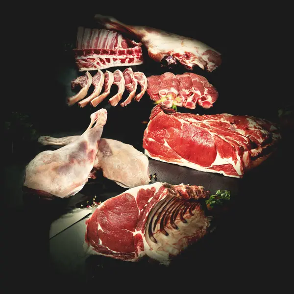Collage or design of different types of raw meat for butcher shop or restaurant.Beef sirloin steaks and T-bone steaks on a stone or black slate background.