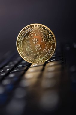 Bitcoin altın sikkeleri, fütüristik ve soyut arka planda siyah dizüstü bilgisayarın klavyesinde. Finans ve yatırım kavramı.