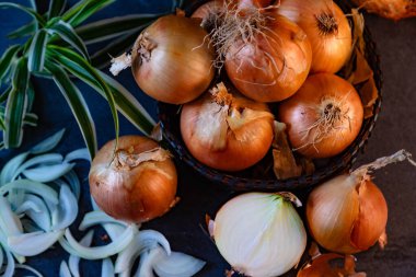 Bir sepet içinde bir sürü soğan ve tabaklarda koyu ve zarif bir koyu dokuya sahip..