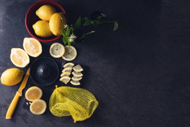 Limon ve limon dilimlerinin koyu ya da siyah çimento ya da taş yüzeyinde sıkma ve bıçak ile zarif bir arka plan tasarımı..